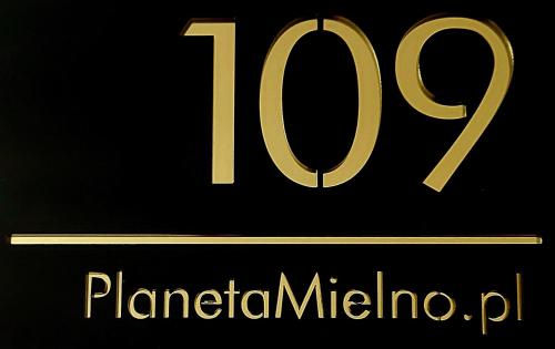 a black and gold sign with the number at Apartament PLANETA MIELNO - centrum, 2 minuty od plaży ! ! ! in Mielno