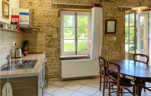 a kitchen with a table and a sink and a window at Cozy Home In St Jean Aux Amognes in Nanton
