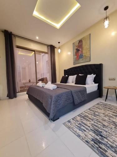 a bedroom with a large bed and a large window at Cozy Studio Private Terrace - fiber Wi-Fi & Netflix in Essaouira