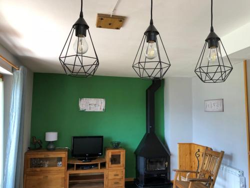 una sala de estar con 3 luces colgando del techo en Apartamentos Ca de Marti, en Bohí