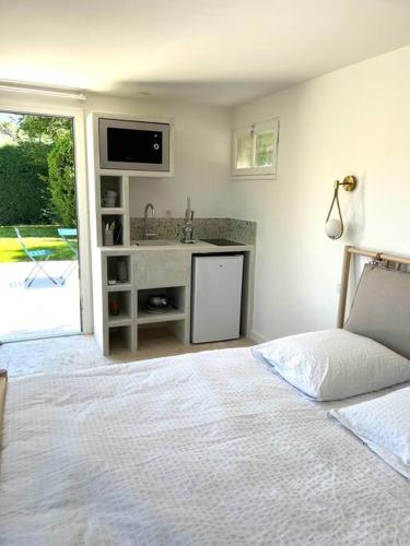 um quarto com uma cama, um lavatório e um balcão em Cocon à l’orée de la forêt em Auriol