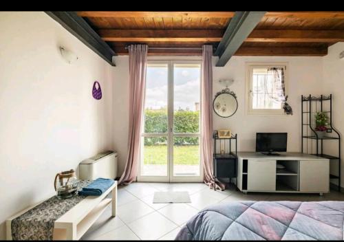 een slaapkamer met een bed en een groot raam bij La camera di cavazzona in Cavazzona