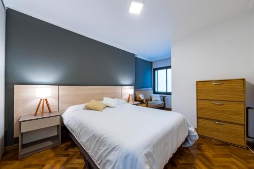 Un dormitorio con una gran cama blanca y una pared azul en Bv Illia 50 - B Nueva Córdoba Edificio con Pileta en Terraza en Córdoba