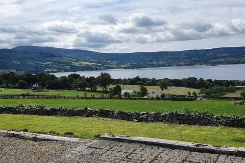 a view of a field and a lake at Cosy self contained cottage with stunning views in Killaloe