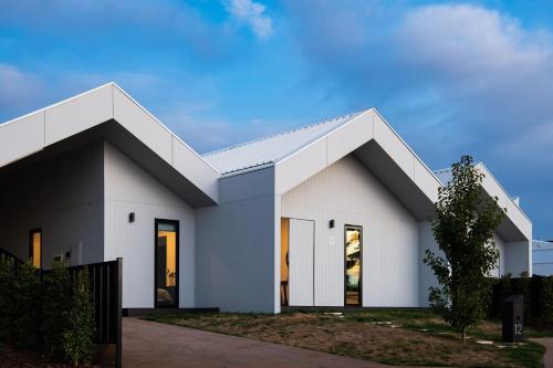 a white house with a white roof at Kura Skymning- sleek Scandinavian design in Daylesford