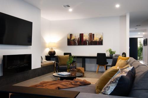a living room with a couch and a tv at Kura Skymning- sleek Scandinavian design in Daylesford
