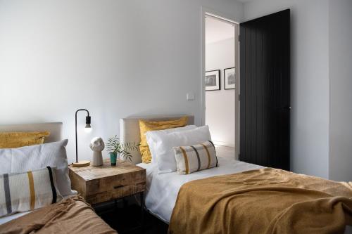 a bedroom with two beds and a mirror at Kura Skymning- sleek Scandinavian design in Daylesford