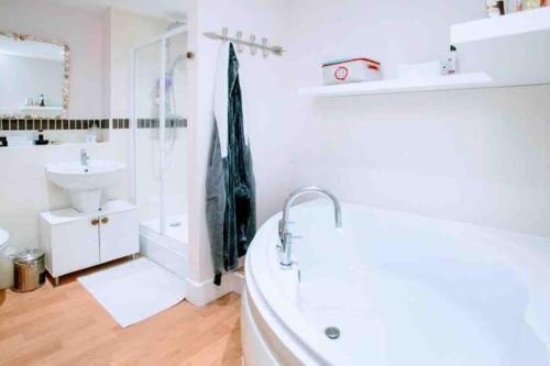 a bathroom with a tub and a sink and a shower at Gold Penthouse - Near Basingstoke hospital 2min in Sherborne Saint John