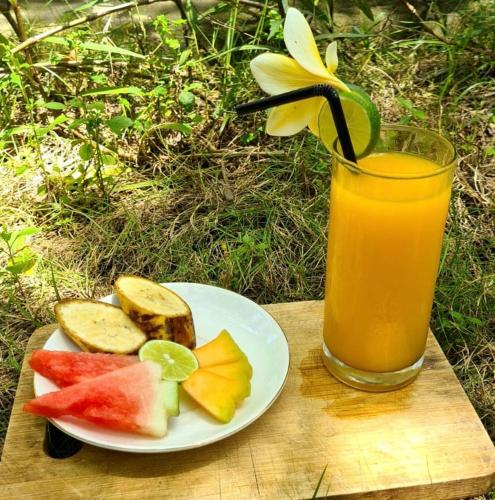 een schaal fruit en een glas sinaasappelsap bij Follow Your Dreams Gili Air in Gili Air