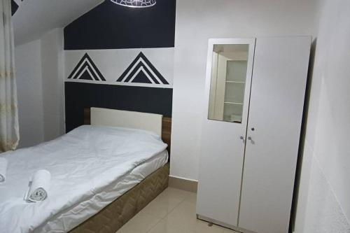 małą sypialnię z łóżkiem i lustrem w obiekcie Daire Beşiktaş Merkez w Stambule