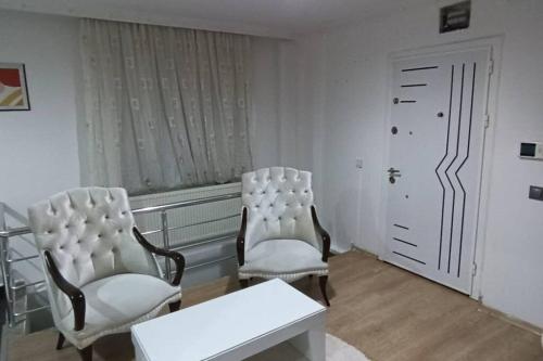 two white chairs and a table in a room at Daire Beşiktaş Merkez in Istanbul