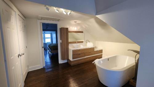 a bathroom with a sink and a bath tub at Les Suites Kaishi in Lévis