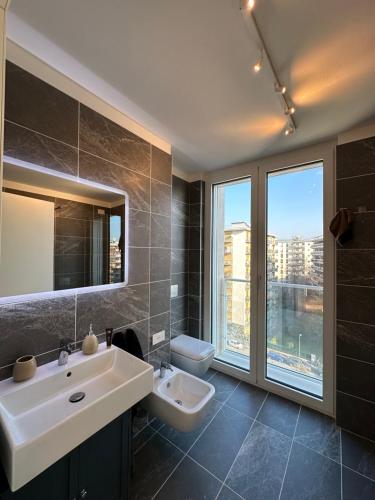 a bathroom with a sink and a toilet and a window at Torre Milano - Luxury modern flat in Milan
