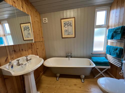 uma casa de banho com 2 lavatórios e uma banheira em Spacious eco-energy timber barn in Chadbury em Offenham
