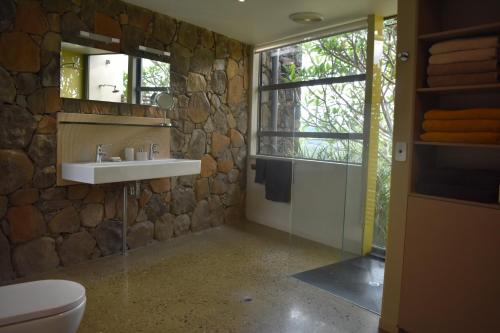 a stone bathroom with a sink and a mirror at Arcadia Views in Witta