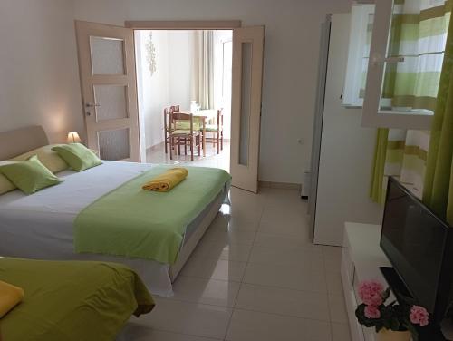 a bedroom with two beds and a television and a table at Apartmani Trubi in Vodice