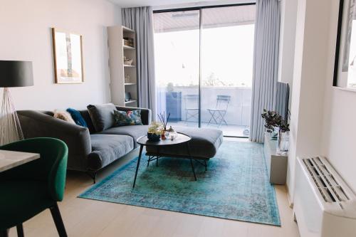 uma sala de estar com um sofá e uma mesa em Design Apartman - Free parking em Szeged