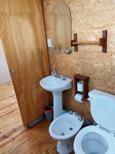 a bathroom with a sink and a toilet and a mirror at Departamento EcoSolar in Reyes