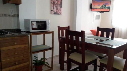 a kitchen with a table and chairs and a microwave at Departamento San Rafael - Sobre Paseo Chile in San Rafael