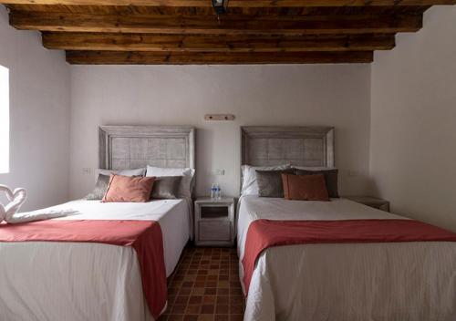 2 Betten nebeneinander in einem Zimmer in der Unterkunft Hotel & Temazcal Hacienda Maxthá in Huichapan