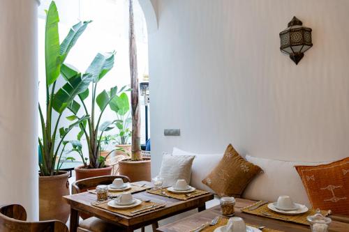 a living room with a couch and tables and plants at Riad Dar Blanche & Spa in Marrakech