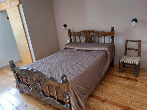 1 dormitorio con cama de madera y silla en Departamento EcoSolar in 