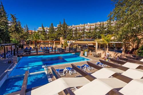 a swimming pool with lounge chairs and a hotel at Casa Balaia 70 in Albufeira