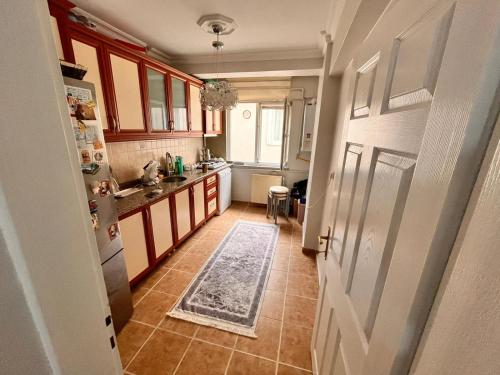 eine Küche mit roten Schränken und eine Tür mit einem Teppich auf dem Boden in der Unterkunft 2 bedroom 5 bed peaceful calm full kitchen,all items available Luxury And relax in Istanbul