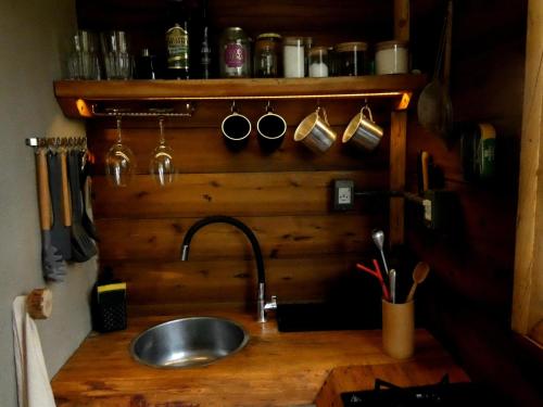 eine Küche mit einer Spüle und einer hölzernen Arbeitsplatte in der Unterkunft Reserva Jacarandá Cabanas in Aiuruoca