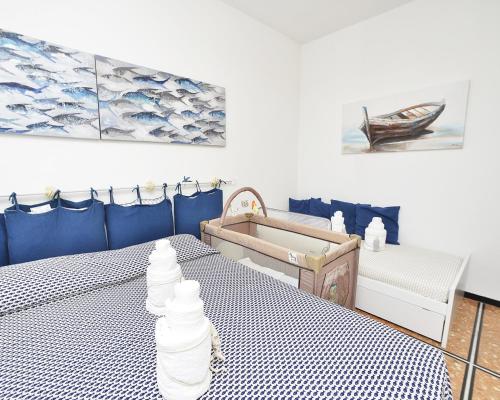 ラパッロにあるAppartamento Rapallo Liguria Maria Joseのベッド2台が備わる客室で、壁には絵画が飾られています。
