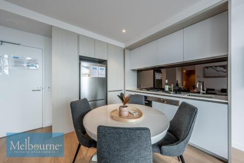 a kitchen and dining room with a table and chairs at Melbourne Private Apartments - Collins Wharf Waterfront, Docklands in Melbourne