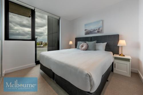 a bedroom with a large bed and a large window at Melbourne Private Apartments - Collins Wharf Waterfront, Docklands in Melbourne