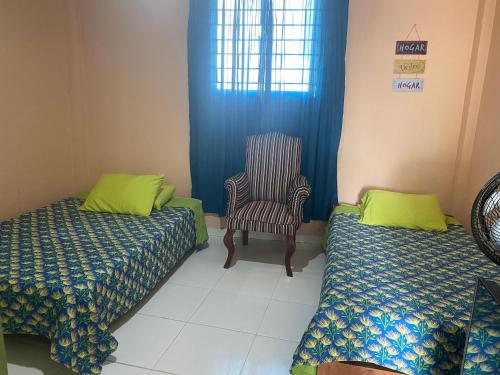 a room with two beds and a chair in it at Habitacion en Cartagena in Cartagena de Indias