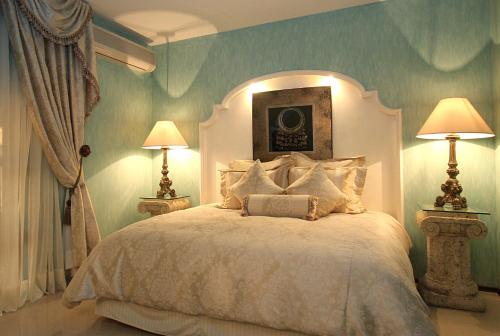 a bedroom with a large bed with two lamps at Palacio Borghese Hotel Boutique - Adults Only in Oaxaca City
