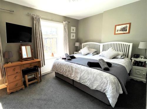 a bedroom with a large bed and a television at Mulberry Cottage in Haworth