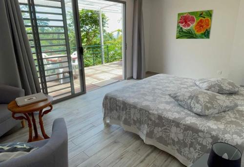 1 dormitorio con 1 cama y puerta corredera de cristal en Tahiti RevaMiti EcoLodge, en Punaauia