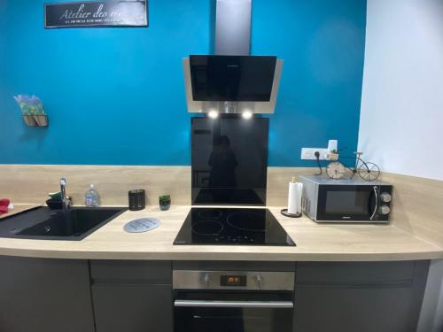 a kitchen with a microwave and a stove top oven at Le bon coin in Le Creusot