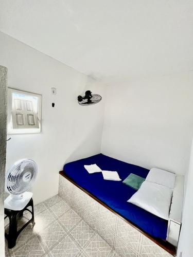 a bedroom with a blue bed and a fan at Pousada Realce in Vera Cruz de Itaparica