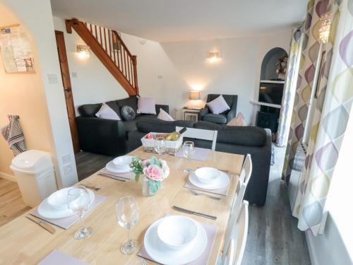 a living room with a table and a couch at Cha Cha's Cottage in Whitby