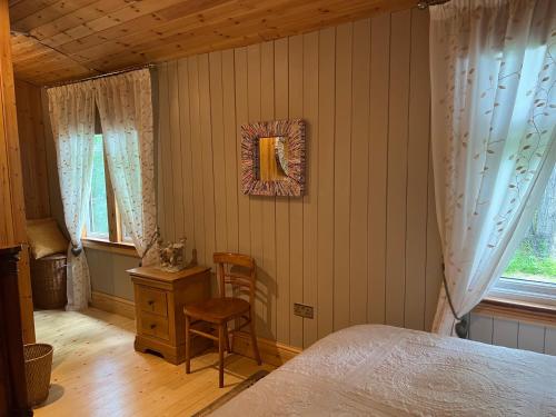a bedroom with a bed and a table and a chair at Spacious eco-energy timber barn in Chadbury in Offenham