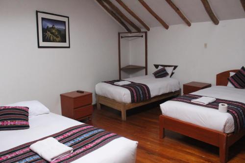 a room with two beds and a mirror at Hostal Turistico ILLAPA CUSCO 119 in Cusco