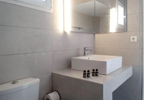 Baño blanco con lavabo y aseo en Palm Suite Blue en Porto Heli