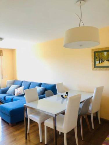 sala de estar con mesa y sofá azul en Piso moderno, en Sarria