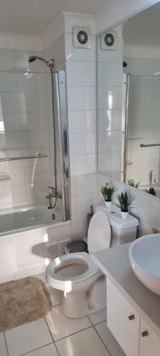 a white bathroom with a toilet and a sink at Bella Vista in Coquimbo