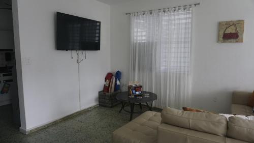 ein Wohnzimmer mit einem Sofa und einem Tisch in der Unterkunft 1A - Large Beach House near Crash Boat Beach in Aguadilla