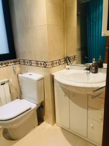 a bathroom with a toilet and a sink at Piso moderno in Sarria