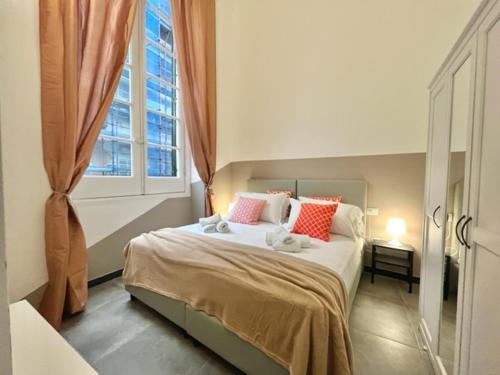 Un dormitorio con una cama con almohadas rojas y una ventana en Happy Family Apartments U Papaviou, en Génova
