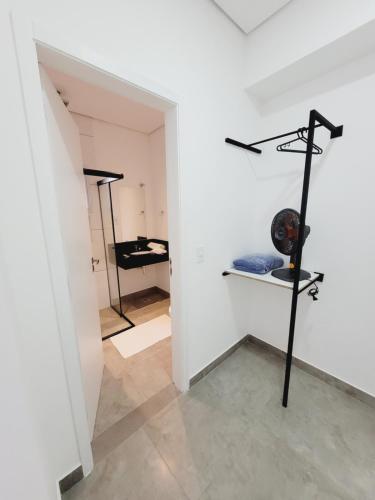 a room with a white wall with shelves and a mirror at Mimos Hospedagem in São Paulo