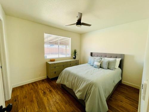 a bedroom with a bed and a ceiling fan at Glendale Gem with Pool & Office in Prime Location in Glendale