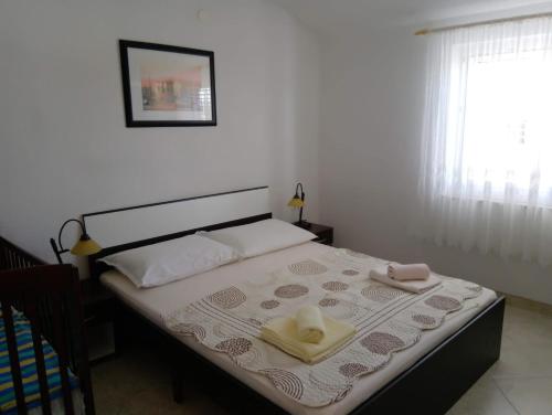 een slaapkamer met een bed met twee handdoeken erop bij Apartment M&M in Gornji Karin